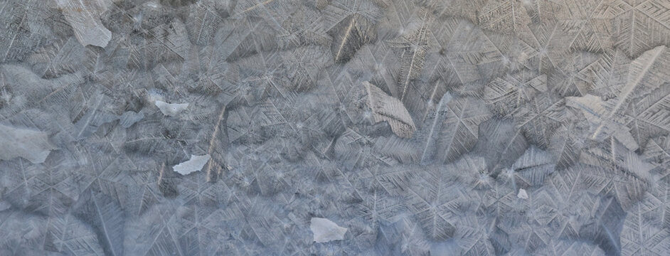 ice pattern on winter glass, abstract background on a cold sunny day