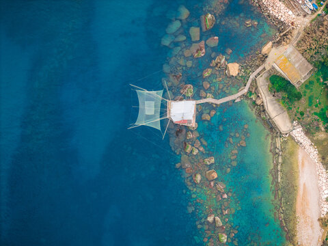 Aerial view of a trabucco standing boldly against the azure sea, connected by a wooden walkway to the rocky shore, San Vito Chietino, Abruzzo, Italy.