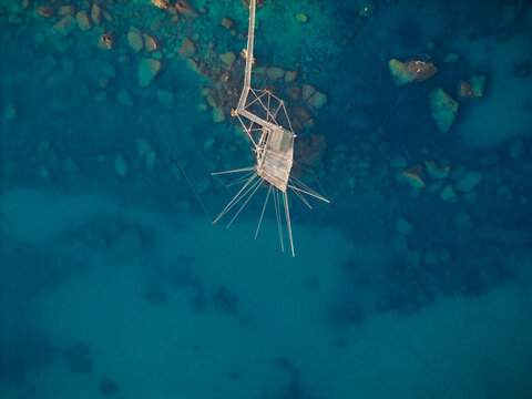 Aerial view of a trabucco structure standing tall amidst the turquoise and azure waters of the Adriatic Sea, San Vito Chietino, Abruzzo, Italy.