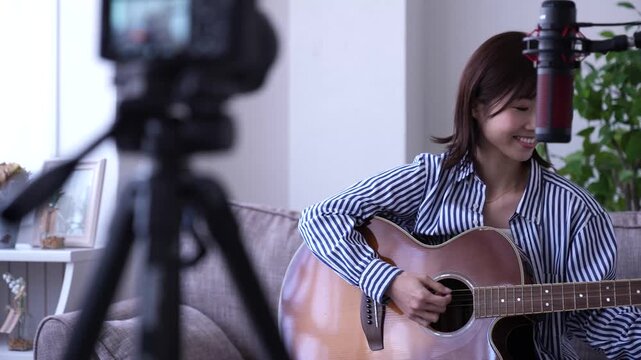 ギターを弾きながら配信する女性