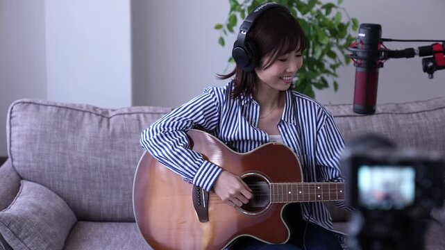 ギターを弾きながら配信する女性