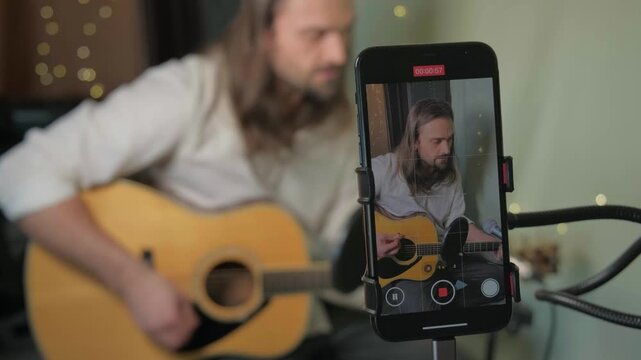 Singer songwriter hosting online acoustic guitar workshop. Indie musician live streaming vocal training and performance tips, building community through social media engagement. Artist live stream