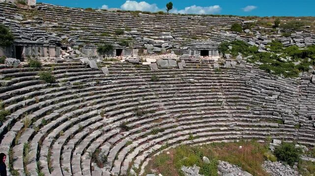 Wide angle view of the ancient amphitheater carved into the mountainside at Termessos Ancient City in Antalya, Turkey. Historic architecture surrounded by nature and rich cultural heritage.