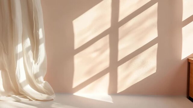 Light enters the room and casts shadows on a wall. A white curtain hangs loosely, adding texture and contrast. The warm tones create a cozy setting in this indoor space