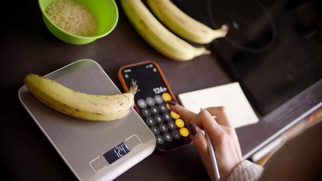 Weighing Banana On Electronic Kitchen Scale. Person Counting Calories And Carbs For Healthy Diet