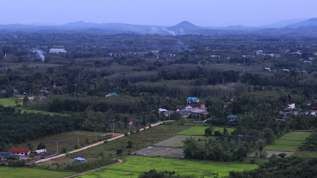 Natural video background of a high-angle atmosphere on a mountain that overlooks the surrounding scenery(mountains, trees,sea)from a scenic vantage point,with a wooden chair for sitting and resting