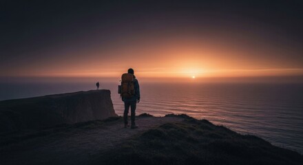 Fototapeta premium Hiker overlooks sunset over ocean