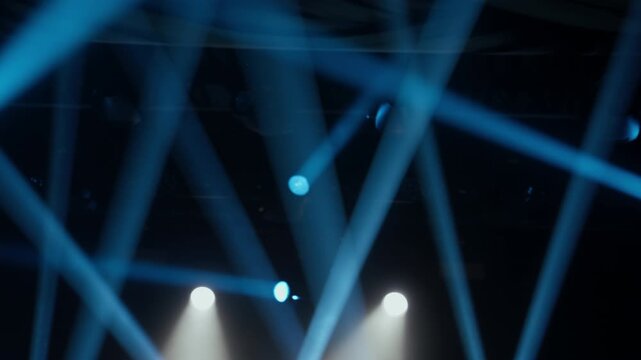 Dynamic stage lighting transitions from cool blue to vibrant warm tones, with sweeping light beams creating an energetic atmosphere. Ideal for concert visuals, events, clubs, and parties