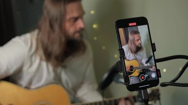 Home studio artist playing acoustic guitar for live broadcast. Singer songwriter sharing emotional music stream on social media, growing independent audience. Live Streaming, Live Performance Stream