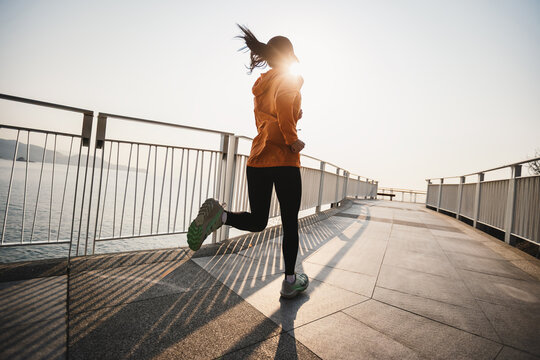 Fitness woman runner running at seaside
