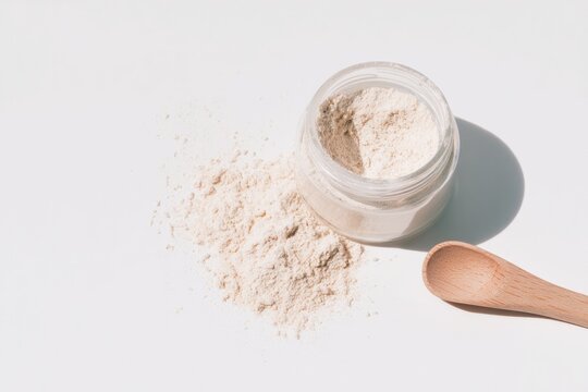 Powdered colostrum in glass jar with wooden spoon, emphasizing h