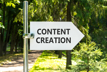 Fototapeta premium Time for content creation symbol. Concept words Content creation on beautiful big white road sign. Beautiful green forest garden trees background. Business time content creation concept. Copy space.