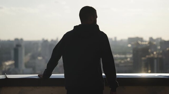 Pensive African American man looking at cityscape from rooftop, life problems