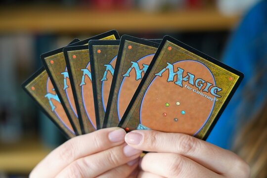 WARSAW, POLAND - MARCH 19, 2026: Person holding a hand of Magic the Gathering, a famous collectible card game published by Wizards of the Coast.