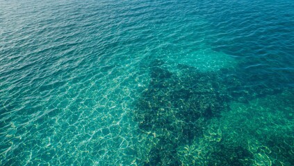 Obraz premium Tranquil Ocean Water Surface with Clear Blue Tones and Rocks Below