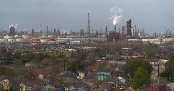 Establishing reveal shot of homes near heavy industry and chemical plants in the Baytown, Texas area