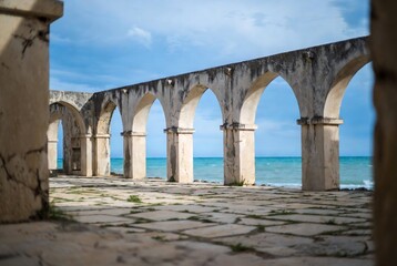 Obraz premium Ancient Roman aqueduct ruins overlooking the sea.