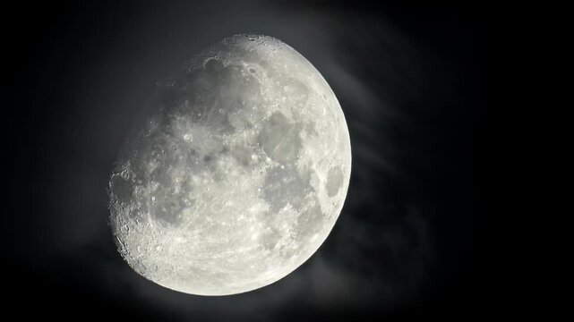 Moon crescent with clouds rolling by in the night sky. Astrophotography real footage of the lunar view.