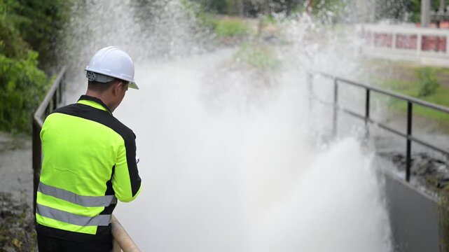 Hydraulic engineers monitor a massive dam water release via spillway gates. Focus on irrigation management, hydroelectric power safety, and flood control infrastructure by technical experts.