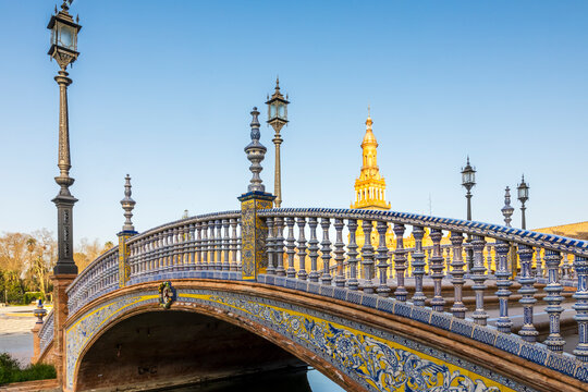 Travel, tourism: Ornate bridge with blue and yellow tilework spans a canal in Plaza de Espa&ntilde;a, Seville, Spain.