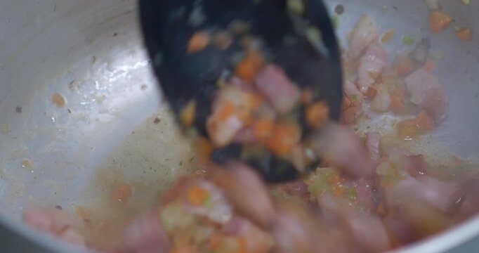 Italian Soffritto Stirring in Pan with Pancetta and Vegetables Close Up
