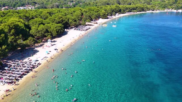 Establishing, panoramic aerial view of the popular Koukounaries beach on the island of Skiathos, Sporades, Greece, with emerald sea and fine sand