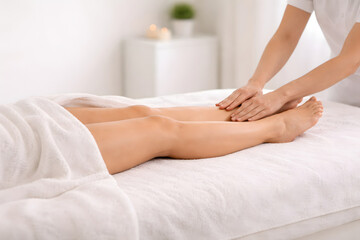Fototapeta premium Hands apply gentle manual lymphatic drainage on client legs during a wellness therapy session for swelling reduction and recovery