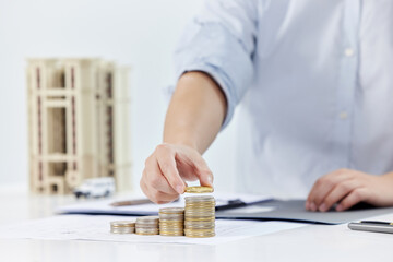 Fototapeta premium Real Estate Investment Growth - Businessman Stacking Coins with House Model