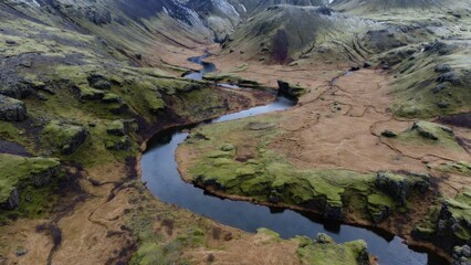 Naklejka premium Meandering river through highland valley with moss and plateaus for landscape background and wallpaper design