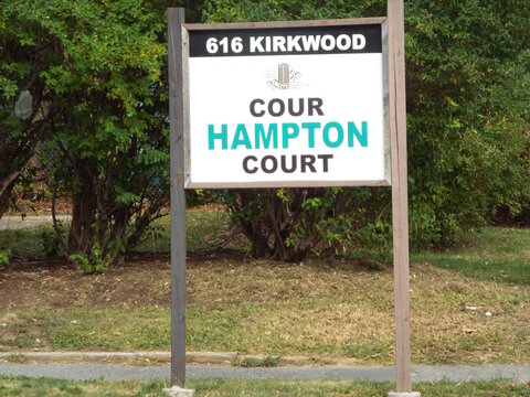 Ottawa, Ontario, Canada-July 22, 2025: A wooden roadside sign identifies "Hampton Court" at 616 Kirkwood Avenue.
