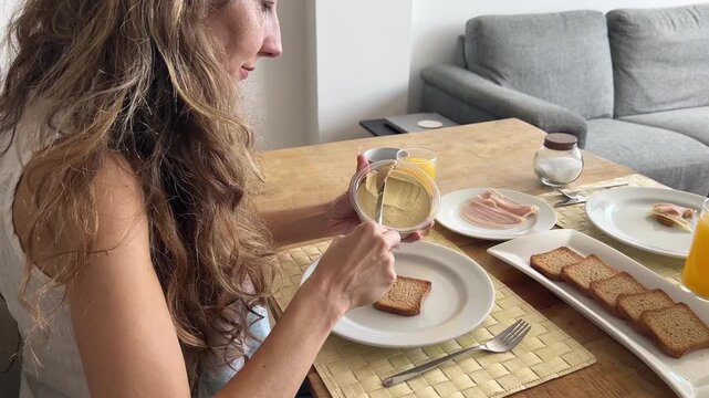 Mujer untando hummus sobre la tostada