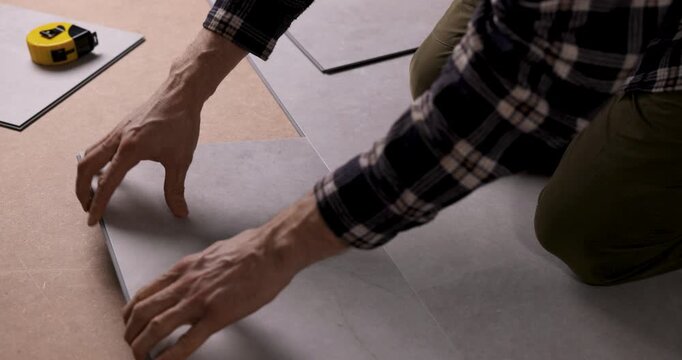 worker installing stone texture vinyl tile flooring