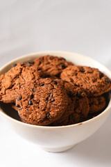 Fototapeta premium Close-up shot of dry chocolate cookies in a white bowl.
