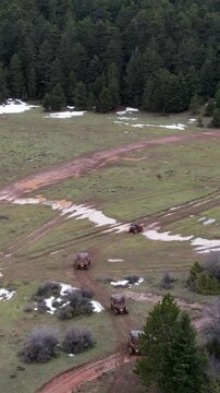 Aerial view of offroad ATVs on muddy paths in snowy mountain field