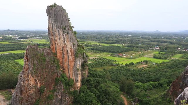 Natural video background of a high-angle atmosphere on a mountain that overlooks the surrounding scenery(mountains, trees,sea)from a scenic vantage point,with a wooden chair for sitting and resting