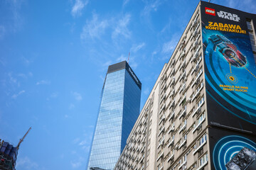 Fototapeta premium Warsaw, Poland - March 18, 2026: Low-angle view of Warsaw skyscrapers against a blue sky with a Lego Star Wars ad on one building.