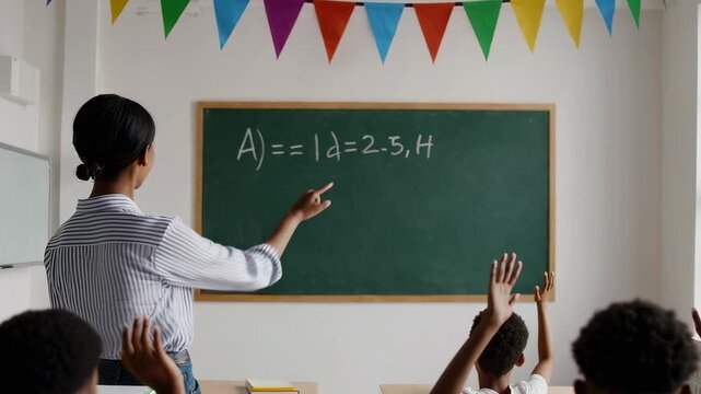 Enthusiastic african american teacher explaining a math equation on the blackboard to a classroom of elementary school pupils who are raising their hands to answer