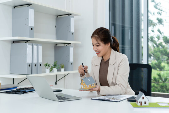 Real Estate Agent Pointing at House Model during Video Call