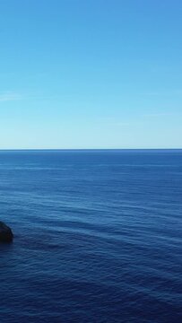 Tranquil blue sea and clear sky meet at the horizon near Capo Palinuro, Italy. Minimalist seascape with serene natural beauty.