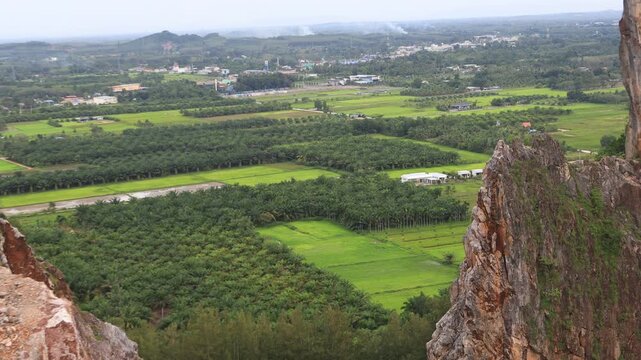 Natural video background of a high-angle atmosphere on a mountain that overlooks the surrounding scenery(mountains, trees,sea)from a scenic vantage point,with a wooden chair for sitting and resting