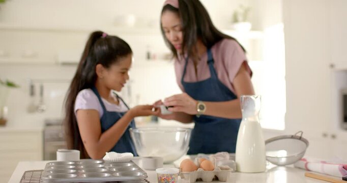 African American mother and child seeing items measuring and mixing in bowl learning to bake