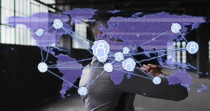 Man reacting to pulsing world map in warehouse guiding tech network nodes linking, showing reach