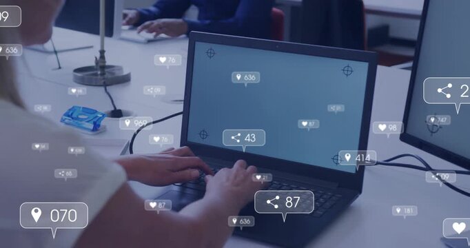 Typing mature woman in white top working on laptop at open office desk, with notifications