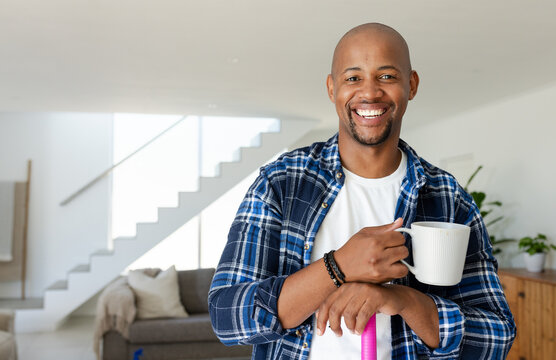 White ceramic mug is sitting by pink cleaning tool while window is casting soft natural light