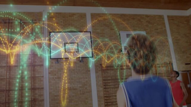 Student raising and releasing basketball in school gym, animated arcs tracing shot for practice