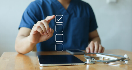 Obraz premium close up young general practitioner hand check box on medical chekclist or opd record to read and diagnose and assess about patient's symptom for healthy and lifestyle concept