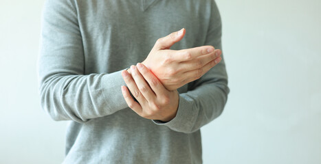 Fototapeta premium close up adult man massage on his hand and arm for relief pain from hard working on white background at home for stiff or cramp symptom or carpal tunnel syndrome concept