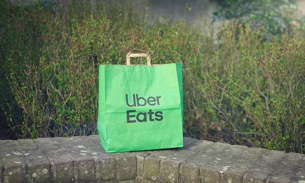 Neu-Ulm, Germany - March, 18, 2026: Paper bag with food from from Uber eats delivery service standing outdoors.