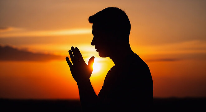 A man in silhouette praying during sunset Vector