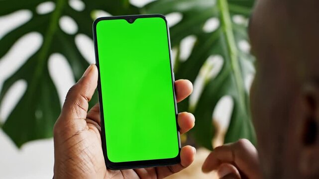 Smartphone with green screen technology interface and foliage background